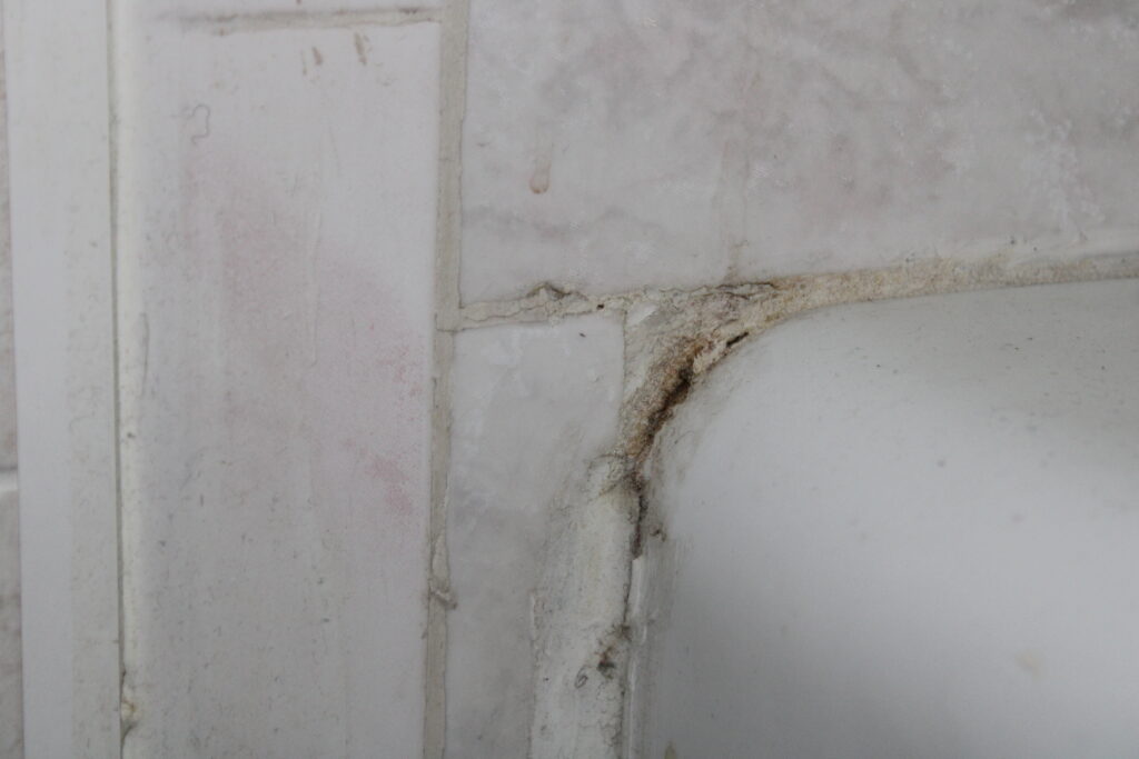 Second example of bad grout and crcacks around the edges of a bathtub.